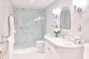 a white bathroom with a shower and a toilet and a sink at Matfen Hall Hotel and Golf - Outstanding New Spa Opening September 15th in Matfen +48 photos