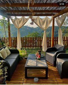 un patio con sofás y una mesa en una terraza de madera. en B&B TERRA DI COLLINA, en Vigliano d'Asti