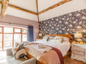a bedroom with a large bed with flowers on the wall at 4 Bed in Ruthin 91098 in Rhewl
