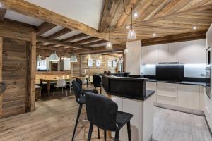 eine Küche und ein Esszimmer mit Holzwänden und -decken in der Unterkunft Residence Savoie - 4 Pièces pour 8 Personnes 664 in Val dʼIsère
