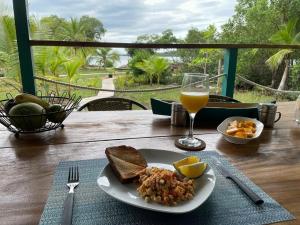 stół z talerzem jedzenia i szklanką soku pomarańczowego w obiekcie Big Bay Bocas - Casita Margarita 