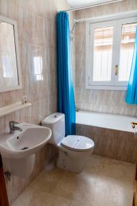 a bathroom with a toilet and a sink and a tub at Casa Juanita in Peñíscola