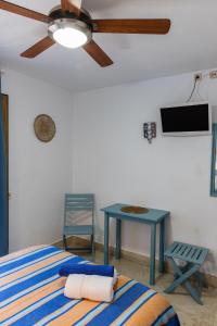 a bedroom with a bed and a table and a ceiling fan at Casa Juanita in Peñíscola