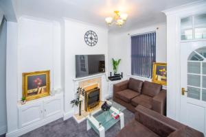 a living room with a couch and a fireplace at Lovely City Home + Free Parking in Manchester