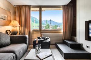 uma sala de estar com um sofá e uma grande janela em Residence Calendal - 2 Pièces pour 4 Personnes 884 em Val dʼIsère