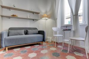 ein Wohnzimmer mit einem Sofa, einem Tisch und Stühlen in der Unterkunft Appartamento Santi Quattro - Colosseo in Rom