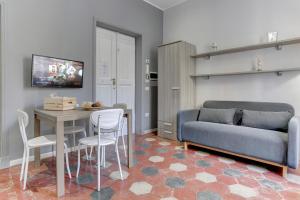ein Wohnzimmer mit einem Sofa, einem Tisch und Stühlen in der Unterkunft Appartamento Santi Quattro - Colosseo in Rom