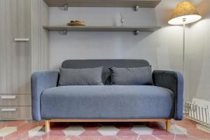 ein blaues Sofa im Wohnzimmer mit Lampe in der Unterkunft Appartamento Santi Quattro - Colosseo in Rom
