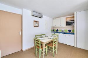 een keuken met een tafel en stoelen in een kamer bij Résidence Saint-Raphaël Valescure - maeva Home - Appartement 3 pièces 6 p 734 in Valescure