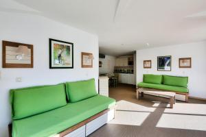 Valescure的住宿－Résidence Saint-Raphaël Valescure - maeva Home - Appartement 3 pièces 6 p 734，客厅配有两张绿色沙发和一张桌子