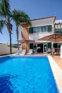 a swimming pool in front of a house at Spacious house with pool in Faro