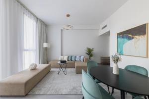 a living room with a couch and a table and chairs at Fresh & Quiet 1BR at Midtown Noor 4 Tower in Dubai