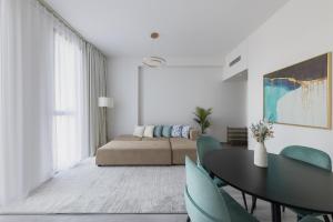 a living room with a bed and a table and chairs at Fresh & Quiet 1BR at Midtown Noor 4 Tower in Dubai
