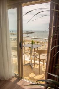 a room with a table and a view of the beach at Wave Beachfront Apartments in Durrës