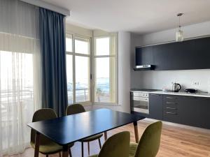 a kitchen with a table and chairs and a table and a table at Wave Beachfront Apartments in Durrës