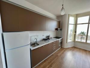 a kitchen with a white refrigerator and a sink at Wave Beachfront Apartments in Durrës