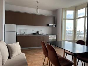 a kitchen and dining room with a table and chairs at Wave Beachfront Apartments in Durrës