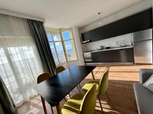 sala de estar con mesa de comedor y sillas en Wave Beachfront Apartments en Durrës
