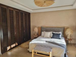 a bedroom with a bed with a bench in it at Villa de vos rêve in Marrakesh