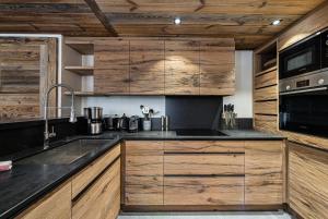 a kitchen with wooden cabinets and a sink at Résidence Petit Alaska - 5 Pièces pour 8 Personnes 684 in Val-d'Isère