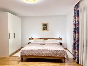 Birkenhof Apartments في باد إندورف: غرفة نوم بسرير في غرفة بيضاء