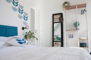 een slaapkamer met een wit bed en een spiegel bij Buen Aire in Cagliari