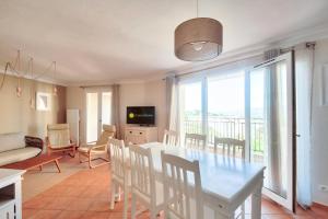 une salle à manger et un salon avec une table et des chaises dans l'établissement Village Pont Royal en Provence - maeva Home - Appartement climatisé 4 pièces 6 personnes - Prestige MAE-3234, à Mallemort