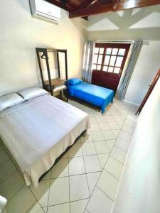 um quarto com uma cama grande e um sofá azul em Casa em Praia do Francês - Alagoas. em Marechal Deodoro