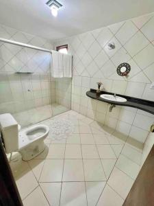 een witte badkamer met een toilet en een wastafel bij Casa em Praia do Francês - Alagoas. in Marechal Deodoro