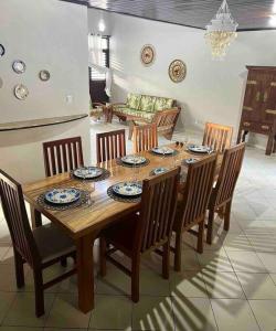 uma sala de jantar com uma mesa de madeira e cadeiras em Casa em Praia do Francês - Alagoas. em Marechal Deodoro
