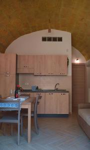 eine Küche mit Holzschränken und einem Tisch im Zimmer in der Unterkunft TerraSicily in Terrasini