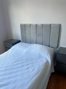 um quarto com uma cama branca com duas mesas de cabeceira em Magnífico apartamento no Rio de Janeiro