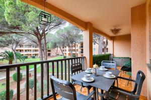 eine Terrasse mit Tisch und Stühlen auf einem Balkon in der Unterkunft Résidence Saint-Raphaël Valescure - maeva Home - Appartement avec vue sur le golf 2 pièces 4 personnes - Prestige - super Home MAE-6264 in Valescure