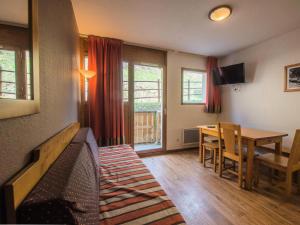 Sala de estar con cama y mesa de comedor en Appartement 2 Pièces Cabine 6 Personnes - été 324, en Orcières