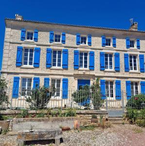 un gran edificio con persianas azules en Maison de 4 chambres avec terrasse a Saint Mande sur Bredoire, 