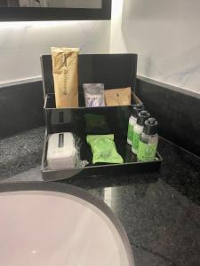 um balcão de casa de banho com uma bandeja com produtos de higiene pessoal e um lavatório em Intercity São Paulo Paulista em São Paulo