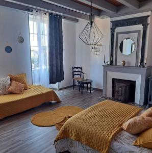 sala de estar con 2 camas y chimenea en Maison de 4 chambres avec terrasse a Saint Mande sur Bredoire, 