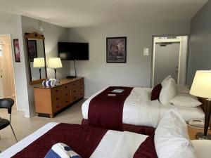 a hotel room with two beds and a mirror at The Grand Resort and Spa & Worthington All Male in Fort Lauderdale