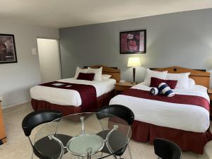 羅德岱堡的住宿－The Grand Resort and Spa & Worthington All Male，酒店客房带两张床和一张桌子以及椅子。