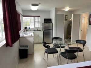 a kitchen with a glass table and black chairs at The Grand Resort and Spa & Worthington All Male in Fort Lauderdale