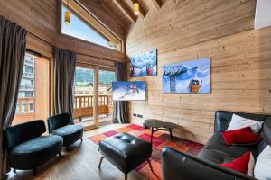 a living room with wooden walls and a couch and chairs at Résidence Chantemerle - 5 Pièces pour 8 Personnes 344 in Courchevel