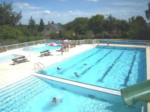 uma grande piscina com pessoas na água em Chalet 3 étoiles - Piscine - eehaed em Merdrignac