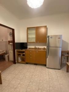 een keuken met een roestvrijstalen koelkast en houten kasten bij Casa Vacanze Tardy e Benech in Savona
