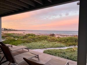 a porch with chairs and a view of the beach at Shades of Blue in St Helena Bay