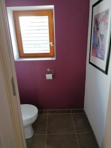 a bathroom with a toilet and a window at Gite du Jardin Roy in Haution