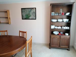 a dining room with a table and a shelf with dishes at Gite du Jardin Roy in Haution +6 photos