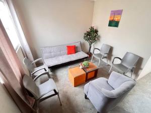 sala de estar con sofá, sillas y mesa en Cómoda y acogedora casa de 1 piso en Trujillo