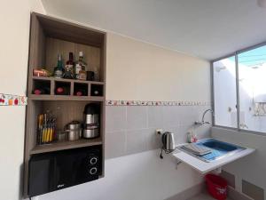 una pequeña cocina con fregadero y encimera en Cómoda y acogedora casa de 1 piso en Trujillo