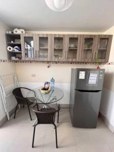 a kitchen with a table and a table and a refrigerator at Cómoda y acogedora casa de 1 piso in Trujillo