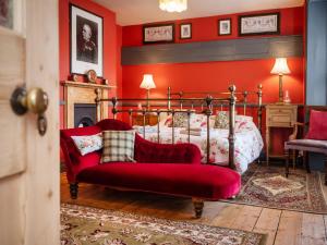 クローマーにあるFinest Retreats - The Old Sunday School & Vestryの赤い壁のベッドルーム1室(ベッド1台付)